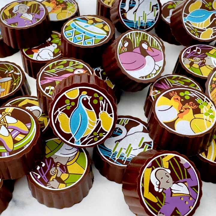 Close-up of handcrafted chocolates with colorful holiday designs.
