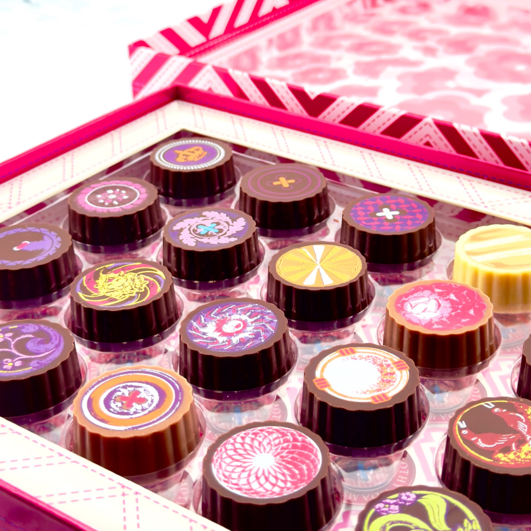 Elegant chocolate gift box with four assorted chocolates, rose petals, and candle, captioned ‘Speak the Libra language of love in chocolate.’