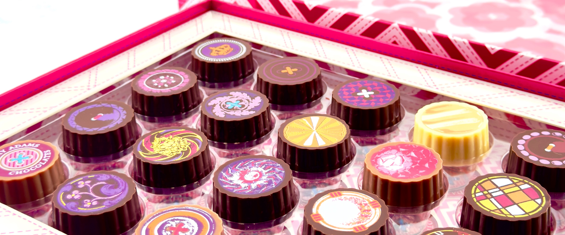 Elegant chocolate gift box with four assorted chocolates, rose petals, and candle, captioned ‘Speak the Libra language of love in chocolate.’